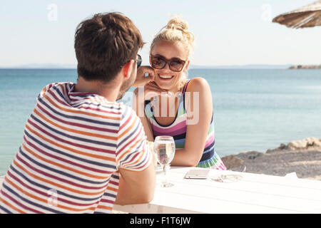 Junges Paar sitzt am Tisch in der Beachbar Stockfoto