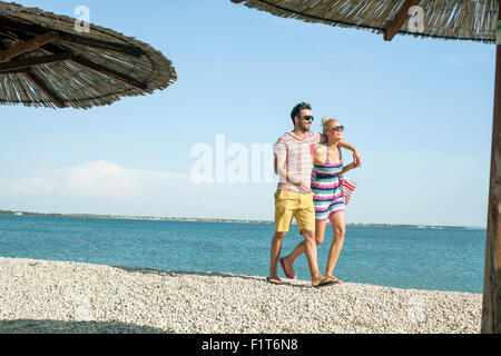 Junges Paar zu Fuß am Strand Stockfoto