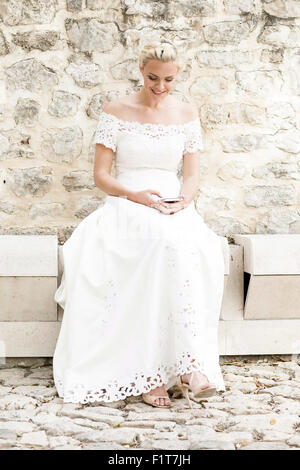 Glückliche Braut in weiß Hochzeit Kleid Text-messaging Stockfoto