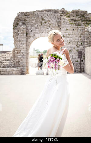 Braut im Hochzeitskleid mit Blumenstrauß Stockfoto
