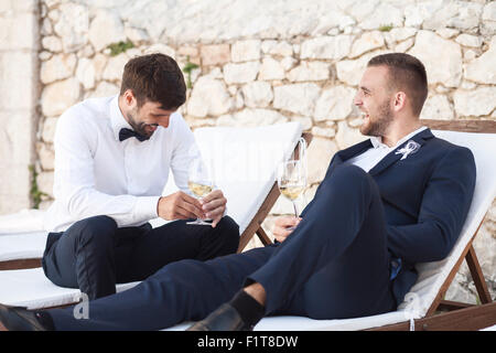 Bräutigam und Freund trinken Champagner auf Hochzeitsfeier Stockfoto