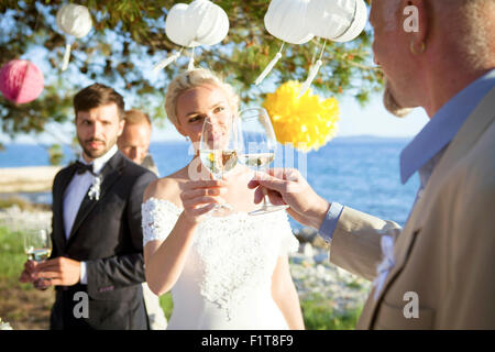 Trinken Champagner bei Hochzeitsfeier am Strand Stockfoto