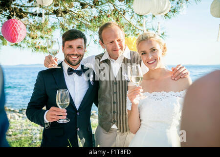 Trinken Champagner bei Hochzeitsfeier am Strand Stockfoto