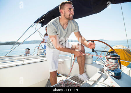 Mann, die Seilwinde auf Segelboot Adria einschalten Stockfoto