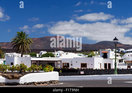 Das Dorf Yaiza mit den Vulkanen des Timanfaya Nationalparks in der Ferne, Lanzarote, Spanien. Stockfoto