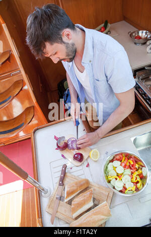 Junger Mann Kochen in Galeere Yacht, Adria Stockfoto