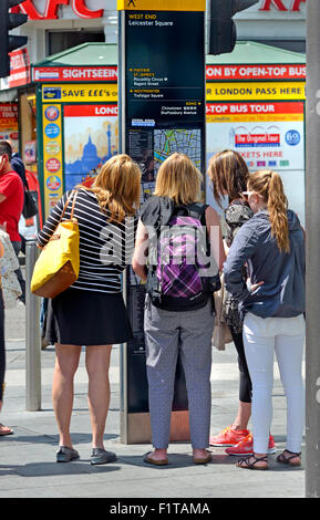 London, Großbritannien. Junge Frauen, die auf einer touristischen Karte in Leicester Square Stockfoto