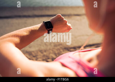 Closeup Aufnahme von jungen weiblichen Jogger betriebsbereit eingestellt und suchen bei Sport Smartwatch. Fitness-Frau ihre Performance überprüfen. Stockfoto
