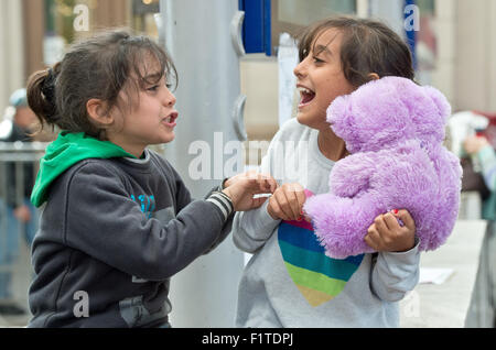 Budapest, Ungarn. 07. Sep, 2015. Zwei syrische Mädchen kämpfen spielerisch um ein Teddybär, während sie darauf warten, ihre Reise nach Westeuropa an der Ost-Bahnhof in Budapest, Ungarn, 7. September 2015 fortsetzen. Die Lage am Bahnhof hat sich wieder entspannt, aber Flüchtlinge halten Ankunft in der Stadt von der serbischen Grenze. Foto: Boris Roessler/Dpa/Alamy Live News Stockfoto