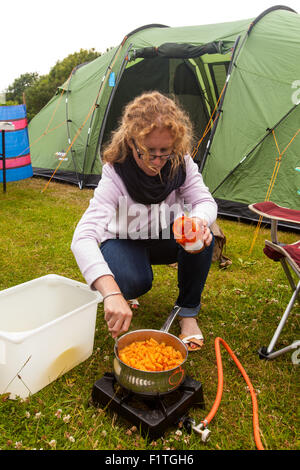 Kochen Frau Nudeln auf einem Campingkocher. Karrageen Campingplatz, Hope Cove, Devon, England, Vereinigtes Königreich. Stockfoto