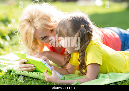 Mutter und Tochter ein Buch im park Stockfoto