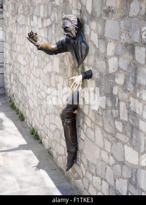 Walker durch Wände: Le Passe-Muraille. Skulptur eines Mannes zu Fuß durch eine Steinmauer in Montmartre Stockfoto