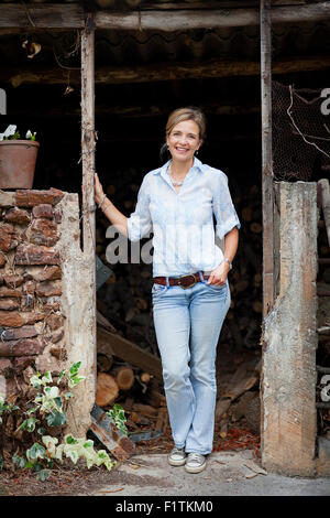 Porträt einer jungen Frau in der Tür eines heruntergekommenen Altbaus stehe Stockfoto