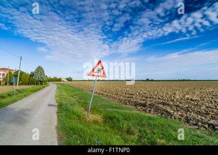 Gefährliche Schulter Ruropean Schild Kiesweg in italienischen Landschaft am Himmelshintergrund Stockfoto