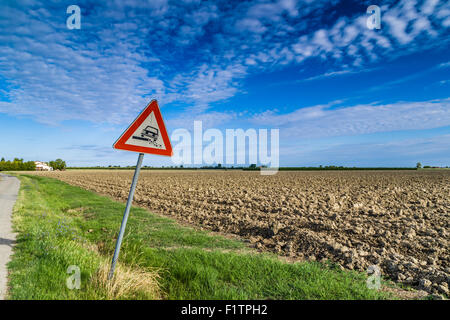 Gefährliche Schulter Ruropean Schild Kiesweg in italienischen Landschaft am Himmelshintergrund Stockfoto