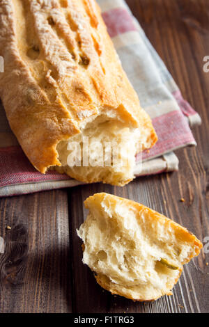 Frisches italienisches Ciabatta Brot mit grünen Oliven auf Holztisch Stockfoto