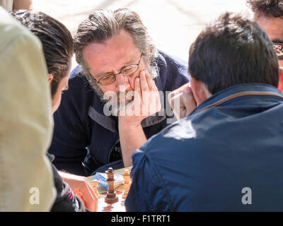 Gartenschach. Den Kopf in der hand, Parisern Konzentrat Schach spielen im Jardin du Luxembourg. Stockfoto