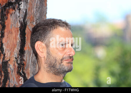 reifer Mann stützte sich auf Baumstamm in ein outdoor Shooting Stockfoto