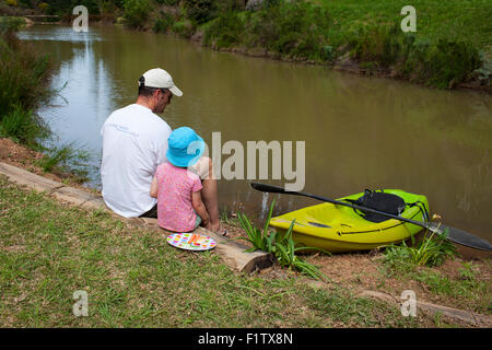 Vater und junge Tochter zusammensitzen See Stockfoto