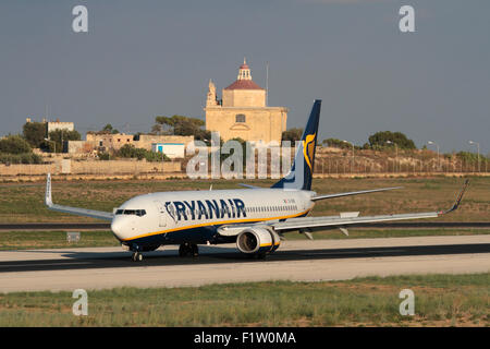 Günstige Flugreisen in der EU. Ryanair Boeing 737-800 Flugzeug bei der Ankunft in Malta, mit Ta'Loretu Kapelle, Gudja, die eine mediterrane Kulisse Stockfoto