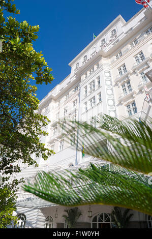 RIO DE JANEIRO, Brasilien - 11. Februar 2014: Tropische Palmen umrahmen die Fassade des Hotel Copacabana Palace, erbaut in den 1920er Jahren. Stockfoto