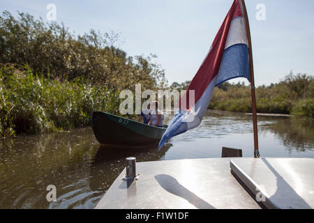 Touristen, die eine Miete Segeln Boot mit niederländischer Flagge im Nationalpark "de Biesbosch" an einem sonnigen Tag in den Niederlanden Stockfoto