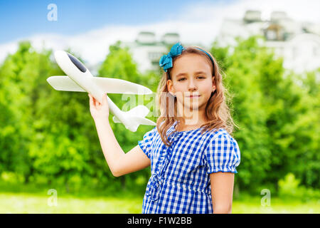 Mädchen hält Flugzeug Spielzeug im grünen Feld Stockfoto