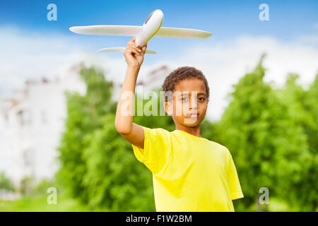Afrikanischen jungen hält Flugzeug Spielzeug alleine zu spielen Stockfoto