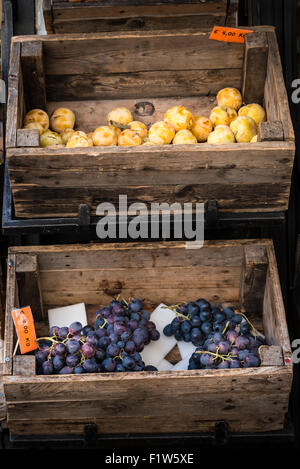 In dem Foto zwei alte Holzkisten mit in der Frucht (Trauben und Pflaumen) Stockfoto