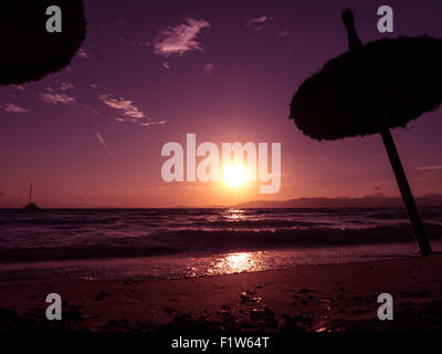 Palm-Sonnenschirme am Strand von El Arenal bei Sonnenuntergang, Mallorca, Balearen, Spanien Stockfoto