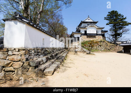 Japan, Takahashi, Bitchu Matsuyama Castle. Blick entlang weiß verputzten Wand des dobei honmaru zum Halten, tenshu, blauer Himmel, strahlender Sonnenschein. Stockfoto