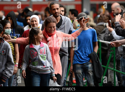 München, Deutschland. 07. Sep, 2015. Eine Frau freut sich über ein Stück Schokolade, die sie von einem Zuschauer kurz nach ihrer Ankunft am Hauptbahnhof in München, 7. September 2015 erhalten. Foto: ANDREAS GEBERT/Dpa/Alamy Live-Nachrichten Stockfoto