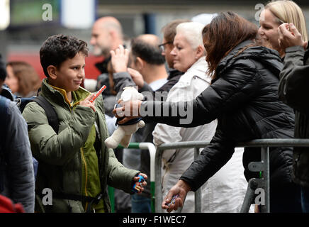 München, Deutschland. 07. Sep, 2015. Ein Junge erhält ein Stück Schokolade und ein Stofftier aus Umstehenden kurz nach seiner Ankunft am Hauptbahnhof in München, 7. September 2015. Foto: ANDREAS GEBERT/Dpa/Alamy Live-Nachrichten Stockfoto