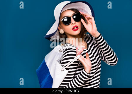 Schöne Brünette Frau posiert mit weißen und blauen Tasche Stockfoto