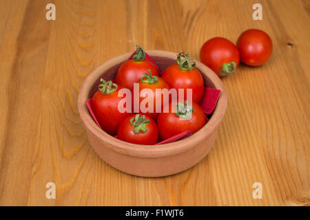 Cherry-Tomaten, hölzernen Hintergrund in einem Topf Stockfoto