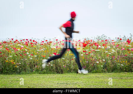 Jogger an Wildblumen gepflanzt am Straßenrand Kante in Seaton Carew. Großbritannien Stockfoto