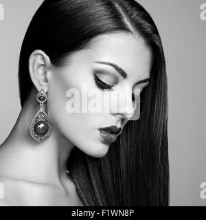 Porträt von schöne Brünette Frau mit Ohrring. Perfektes Make-up. Modefoto. Schwarz / weiß Stockfoto