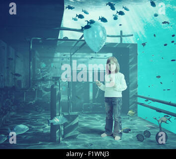 Kleines Mädchen mit Ball unter Wasser. CG und Foto-Elemente-Zusammenstellung Stockfoto