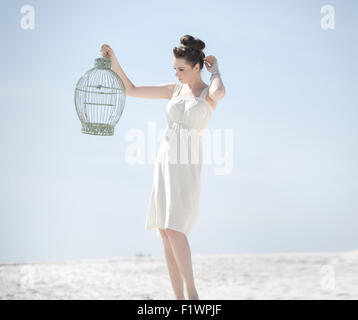 Elegante Dame mit dem goldenen Vogelkäfig Stockfoto