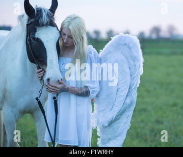 Blonder Engel, die auf der Suche nach dem weißen Pferd Stockfoto