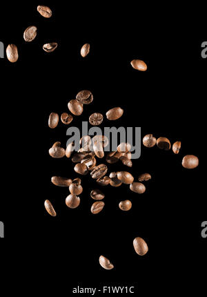 fallende Kaffeebohnen auf dem schwarzen Hintergrund. Stockfoto