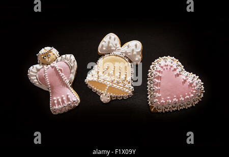 Lebkuchen auf dem dunklen Hintergrund. Engel, Glocke und Herz. Thema Weihnachten. Stockfoto