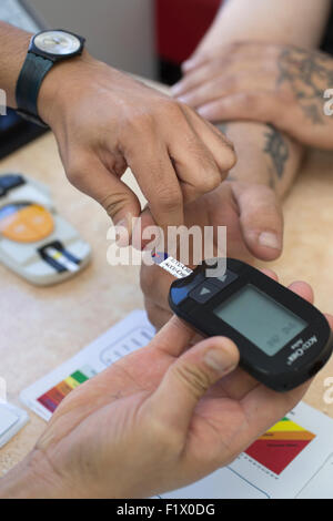 Bauarbeiter, die unter einem Diabetes-Test und der allgemeine Gesundheitszustand überprüfen auf Website, England, UK Stockfoto