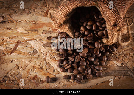 Tasche mit Kaffeebohnen isoliert auf dem hölzernen Hintergrund. Stockfoto