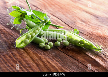 grüne Erbsen auf dem hölzernen Hintergrund. Stockfoto