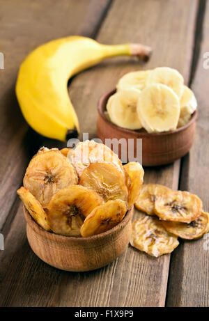 Hausgemachte Bananen-chips in Schüssel auf Holztisch Stockfoto