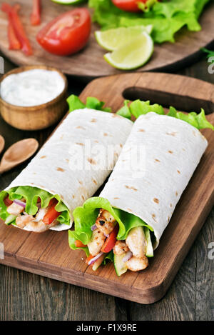 Tortilla wraps auf Schneidebrett auf Holztisch Stockfoto