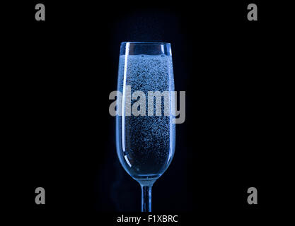 blaues Glas Champagner auf schwarzem Hintergrund. Stockfoto