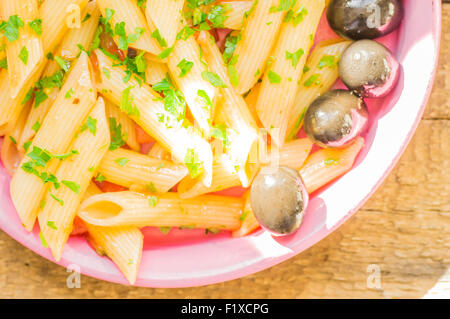 Italienische Pasta mit Oliven in einer rosa Platte Ansicht von oben Stockfoto