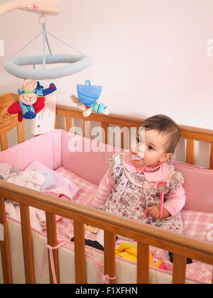 Babymädchen in Krippe Stockfoto